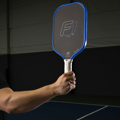 man's arm and hand holding a FLiK F1 USAP approved pickleball paddle