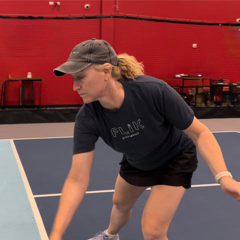 woman dinking with FLIK pickleball paddle and vintage distressed hat