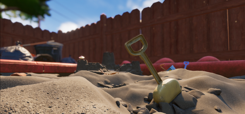 sandbox with red fence in the background