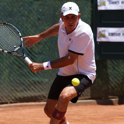 Fred Robinson looking at a tennis ball he is preparing to hit